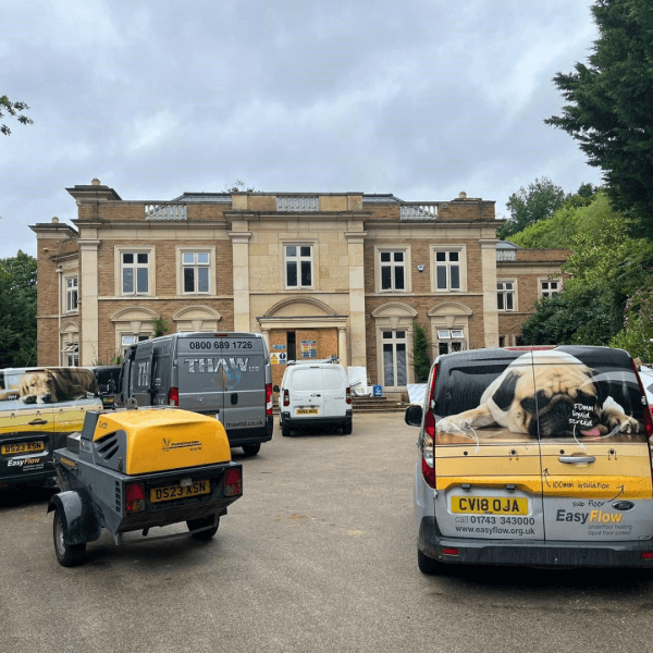 The trucks of the underfloor heating Shropshire team parked outside a commercial property