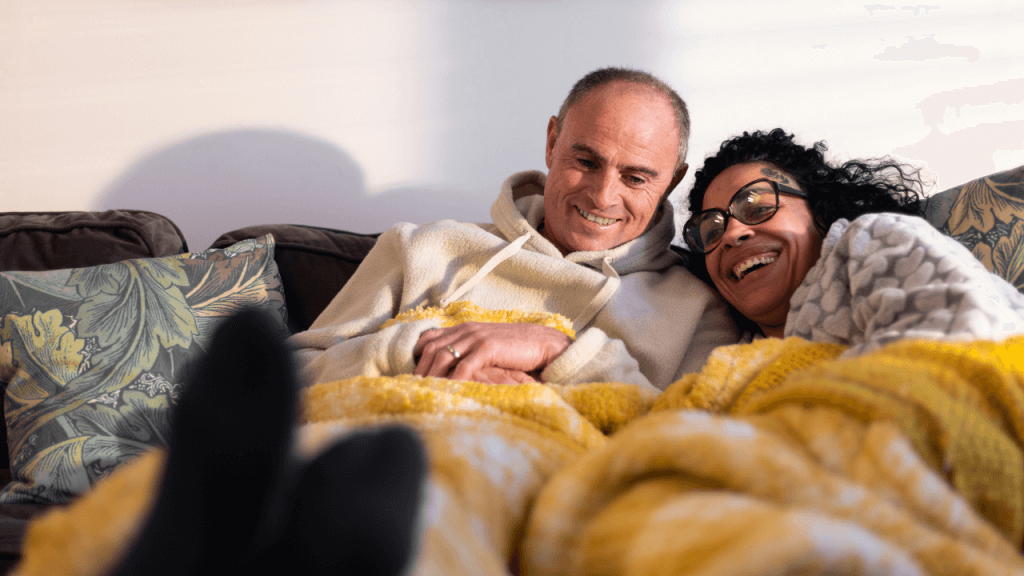 A couple wrapped in a blanket with energy efficient heating